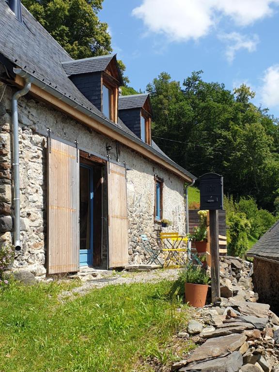 un vecchio cottage in pietra con una porta aperta di LESPONNE Gîte Il granaio di Lesponne a Lesponne