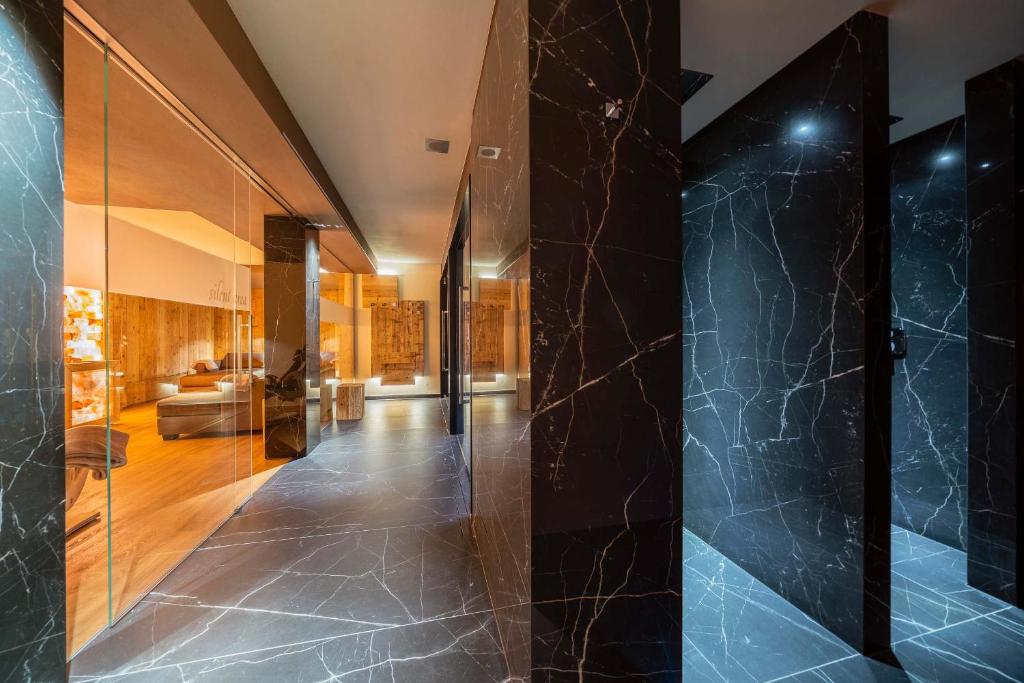 um corredor com paredes de mármore preto e uma sala de estar em Hotel Cristallino d'Ampezzo em Cortina dʼAmpezzo