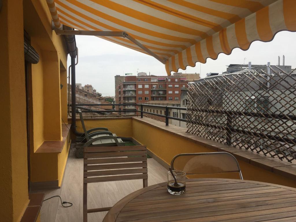a balcony with a wooden table and chairs on a roof at Ático en el centro de Logroño in Logroño