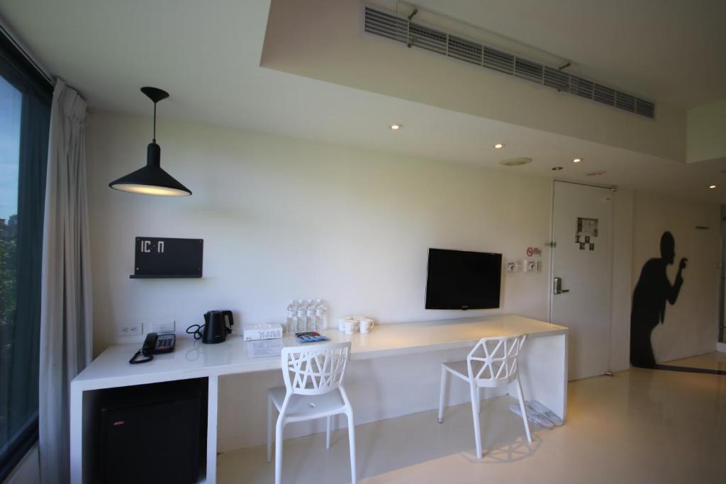 a kitchen with a white counter and two chairs at Hotel Papa Whale-Kaohsiung Formosa Boulevard in Kaohsiung