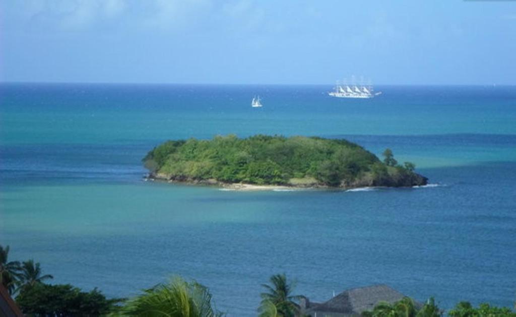 an island in the ocean with two ships in the water at Amazing Beach View Apartments in Castries