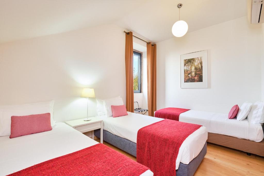 a hotel room with two beds and a red blanket at Sintra Bliss A Part in Sintra