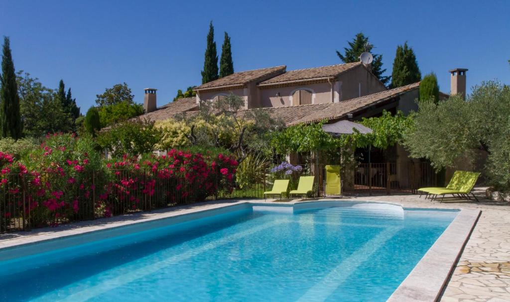 a villa with a swimming pool and a house at Maison de campagne au charme provençal in Saint-Rémy-de-Provence