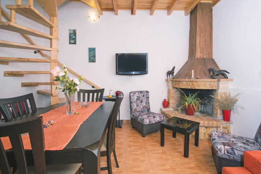 une salle à manger avec une table et une cheminée dans l'établissement Spiti Maria, à Valaneíon