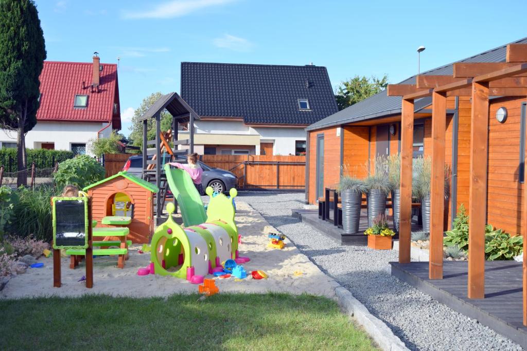 einen Spielplatz mit Rutsche und Spielset in der Unterkunft DOMKI WYPOCZYNKOWE ZOSIA I HELENKA in Puck