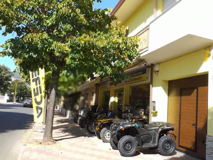 eine Reihe von vier ATvs, die außerhalb eines Gebäudes geparkt sind in der Unterkunft B&B THE BIKERS in Guspini