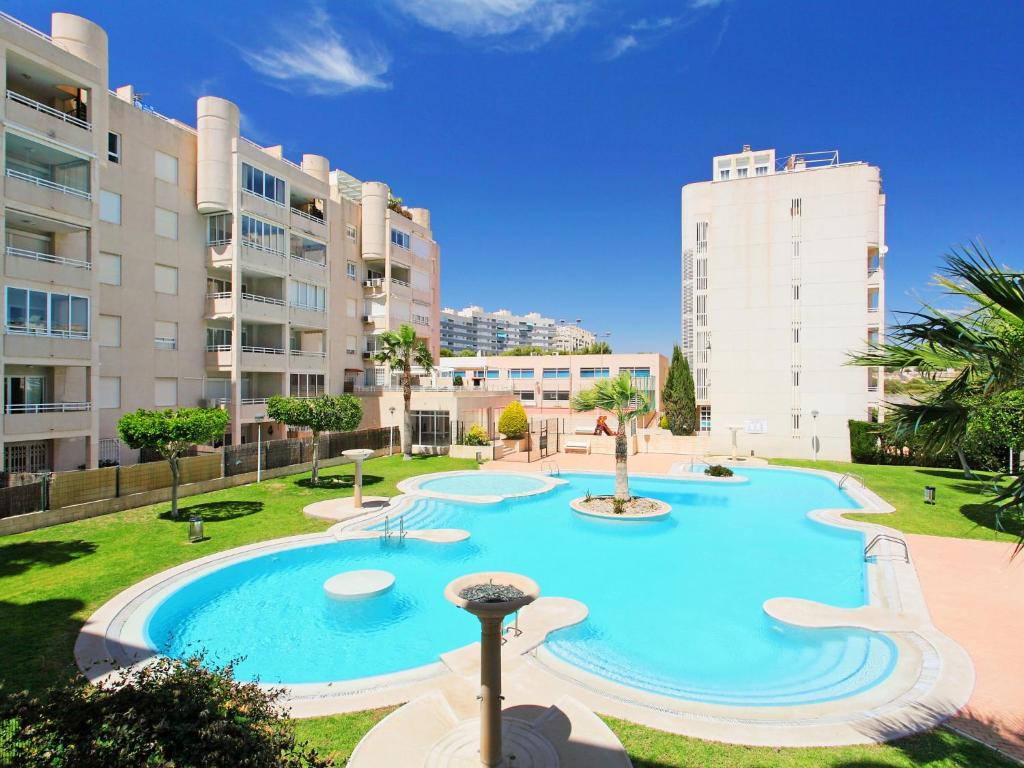 a large swimming pool in a park with tall buildings at Apartment Cabo Mar by Interhome in El Campello
