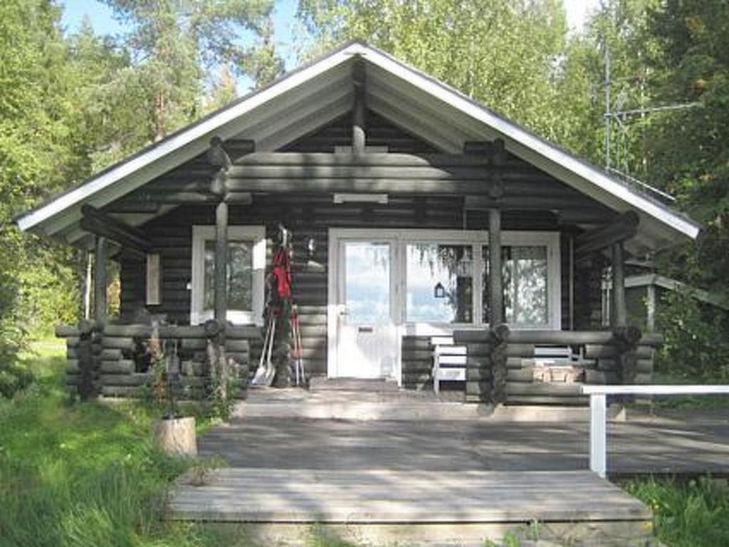 a small log cabin with a porch and a door at Holiday Home Lähesniemi by Interhome in Hokkanen