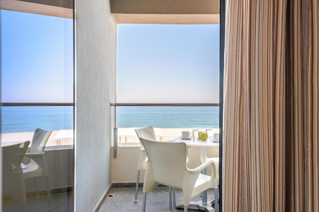 ein Esszimmer mit einem Tisch und Meerblick in der Unterkunft Despina Apartments in Platanias