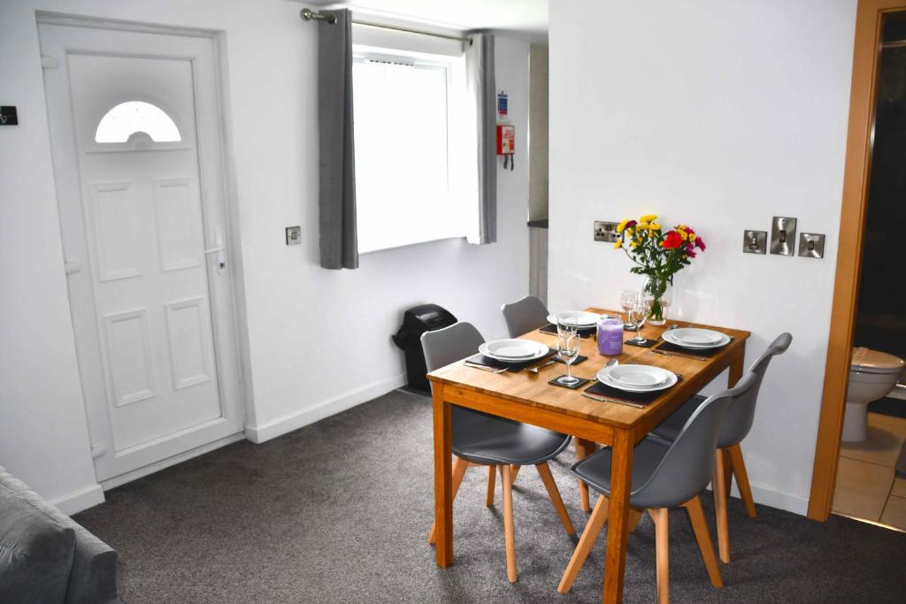 uma sala de jantar com uma mesa de madeira e cadeiras em Ilfracombe Apartments em Ilfracombe