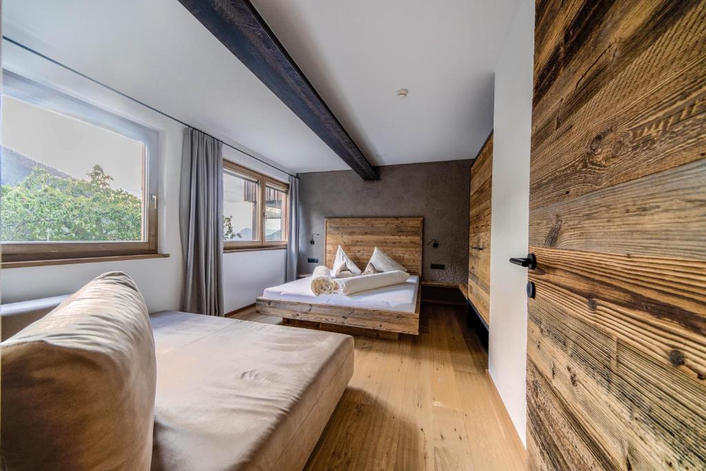 a bedroom with a bed and a large wooden door at Sonnleiten Sonnenadler 1 in Collepietra