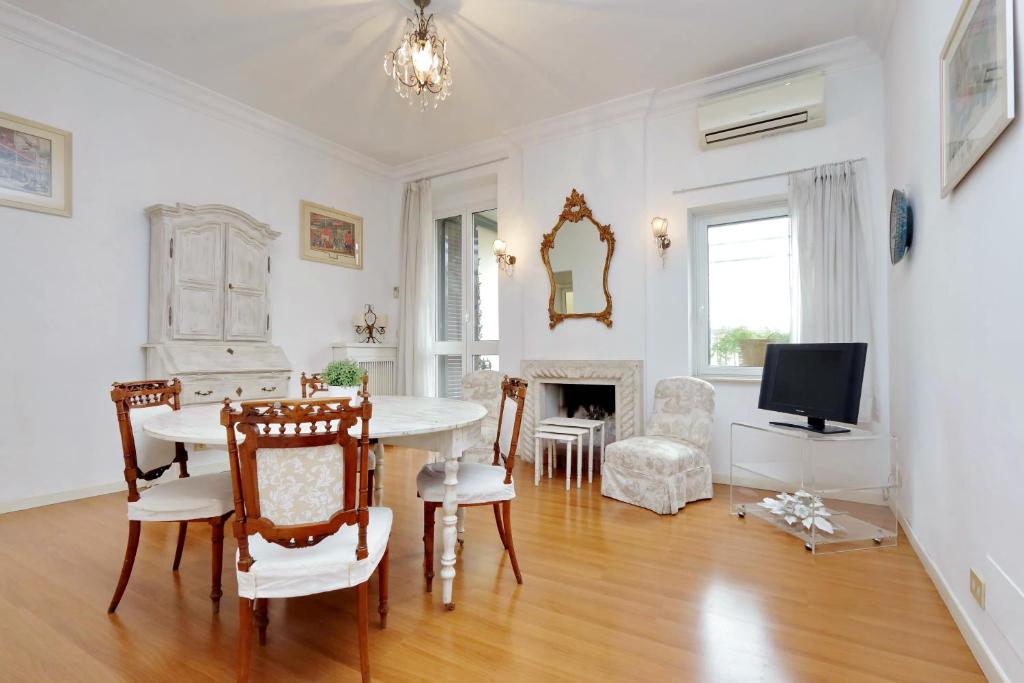 een woonkamer met een tafel en stoelen en een televisie bij RomeAsYouLike - Arancio Apartments N°9 in Rome