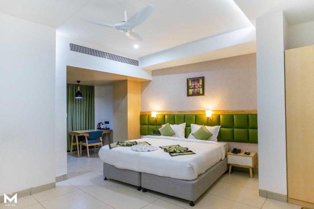 sypialnia z dużym łóżkiem i stołem w obiekcie THE M HOTEL w mieście Raipur