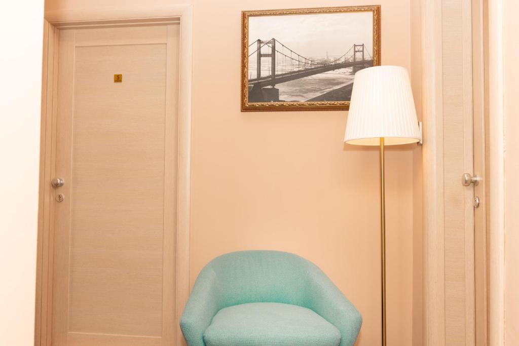 a room with a blue chair and a lamp at Skadarlija Suites in Belgrade