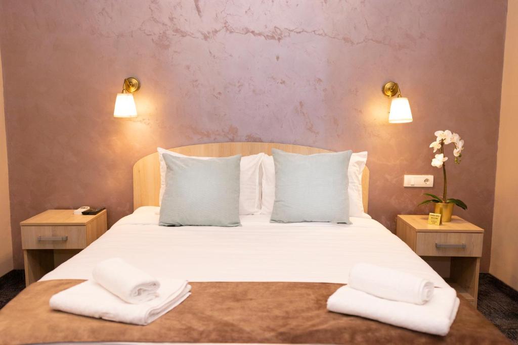 a bedroom with a bed with two towels on it at Skadarlija Suites in Belgrade