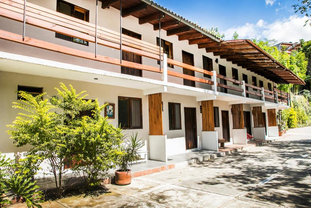 un grand bâtiment blanc avec des arbres devant lui dans l'établissement Meson de Valle Hotel, à Valle de Bravo