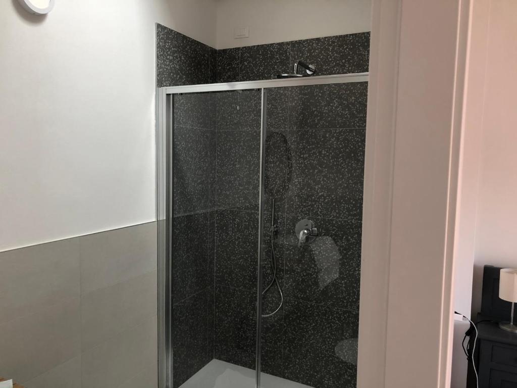 prysznic ze szklanymi drzwiami w łazience w obiekcie Corte del Garda Home w mieście Castelnuovo del Garda