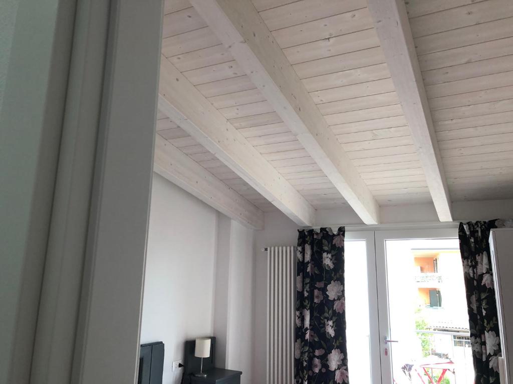 Pokój z białym sufitem i oknem w obiekcie Corte del Garda Home w mieście Castelnuovo del Garda