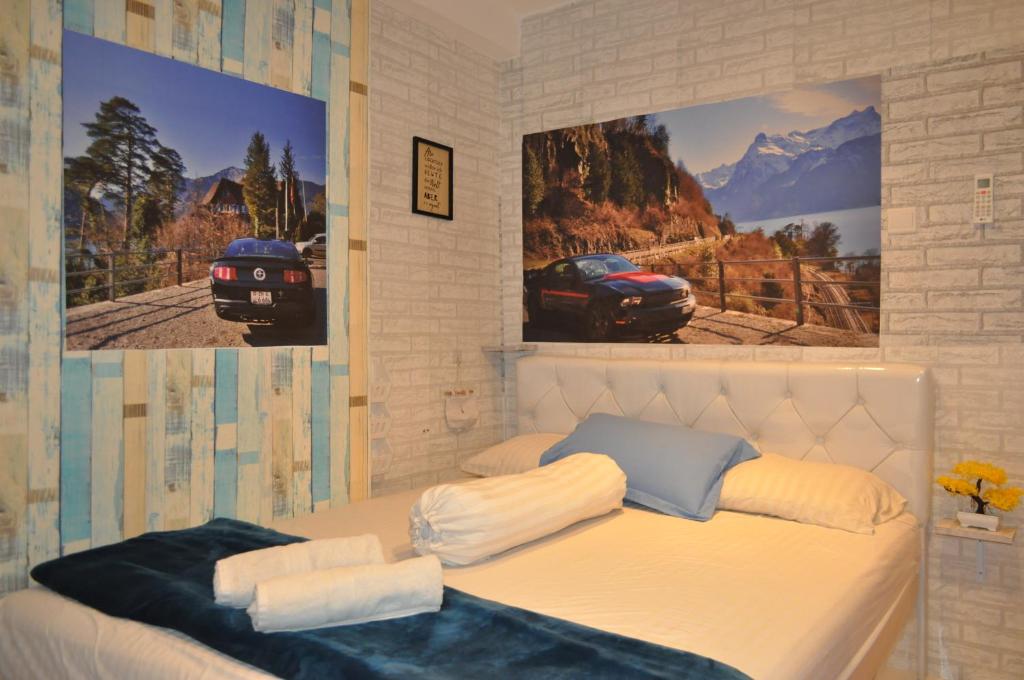a bedroom with two pictures of a car on the wall at Apartment Grand Asia Afrika MUSTANG in Bandung
