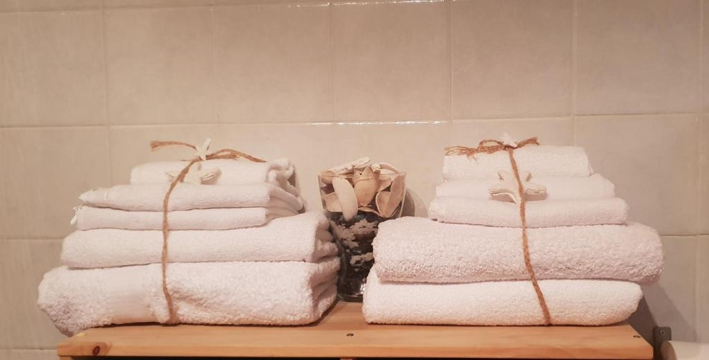 trzy stosy ręczników siedzące na stole w łazience w obiekcie Apartment Inn w mieście Aci Castello