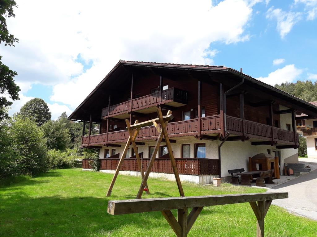 een groot gebouw met een veranda en een schommel bij Gasthof - Pension zur Post in Achslach