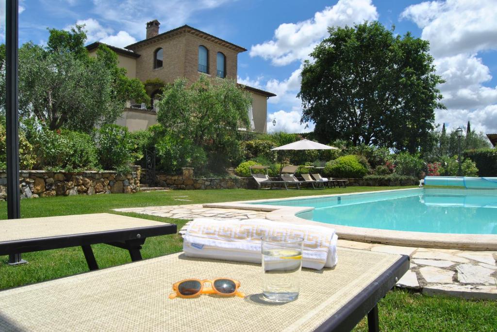 - une table avec des lunettes de soleil et des lunettes à côté de la piscine dans l'établissement Villa La Valiana - Full Estate in Montepulciano - HEATED POOL, à Valiano