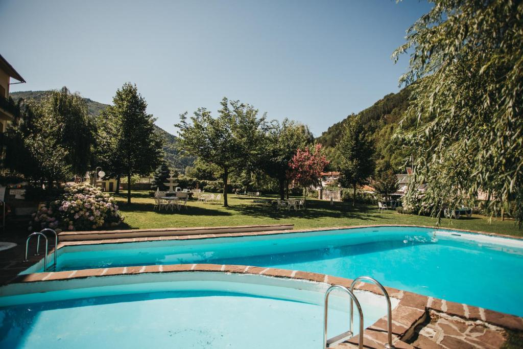 a swimming pool with a mountain in the background at Hotel Catalunya Park in Ribes de Freser