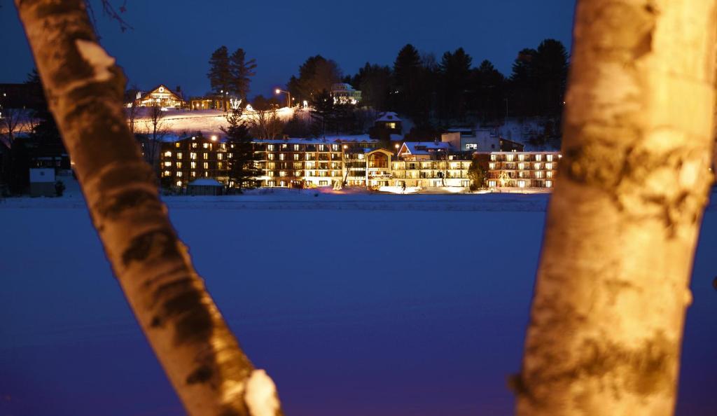 - une vue sur un bâtiment la nuit avec de la neige dans l'établissement Golden Arrow Lakeside Resort, à Lake Placid