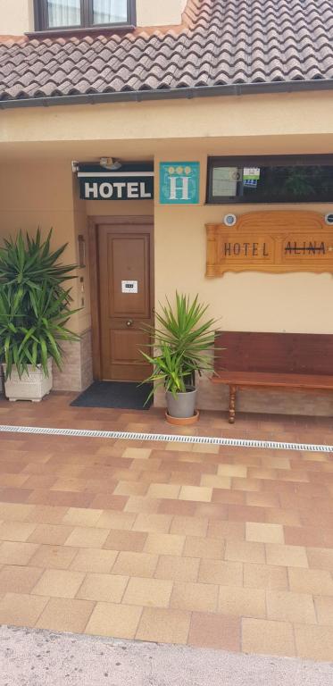 カンガス・デル・ナルセアにあるHotel Alinaの建物の前にベンチ付きのホテル