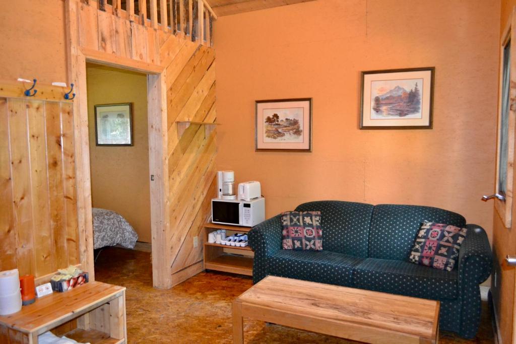 a living room with a couch and a microwave at Schott's Lake Conference & Resort in Sundre