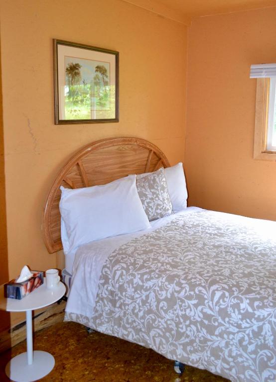 a bedroom with a bed and a picture on the wall at Schott's Lake Conference & Resort in Sundre
