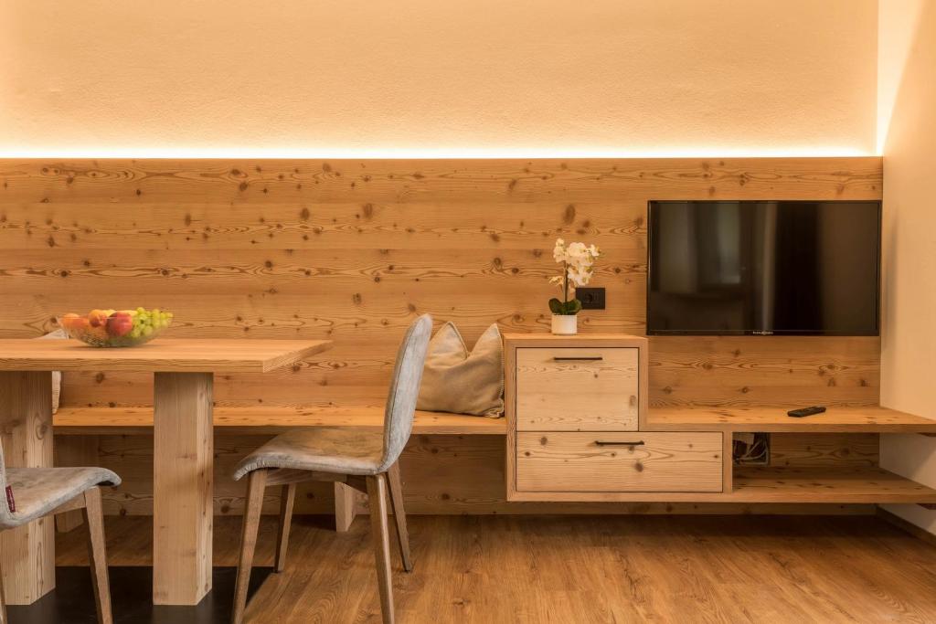 a dining room with a table and a tv at Apt Mirko - Haus Kostner in Santa Cristina in Val Gardena
