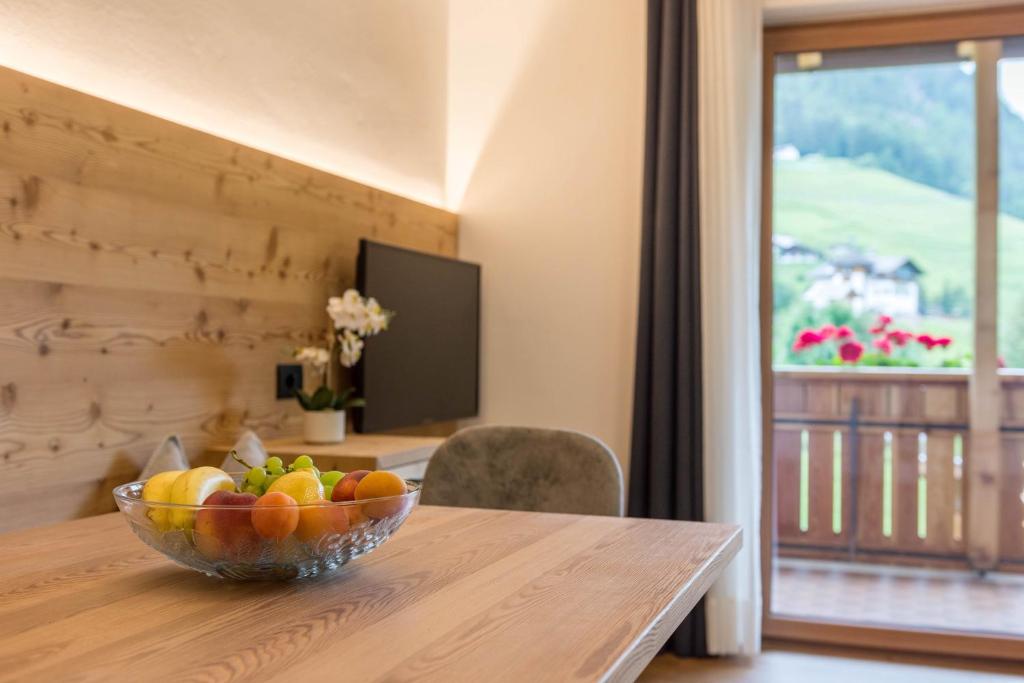 uma taça de fruta sentada numa mesa de madeira em Apt Mirko - Haus Kostner em Santa Cristina in Val Gardena