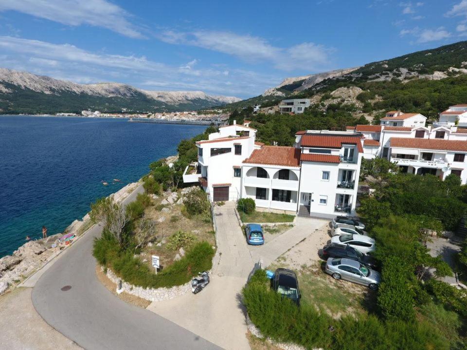 un gruppo di edifici e auto parcheggiati accanto all'acqua di Apartment N4 D&D, Baska a Baška