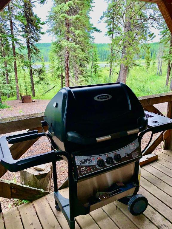 a grill sitting on top of a wooden deck at Schott's Lake Conference & Resort in Sundre