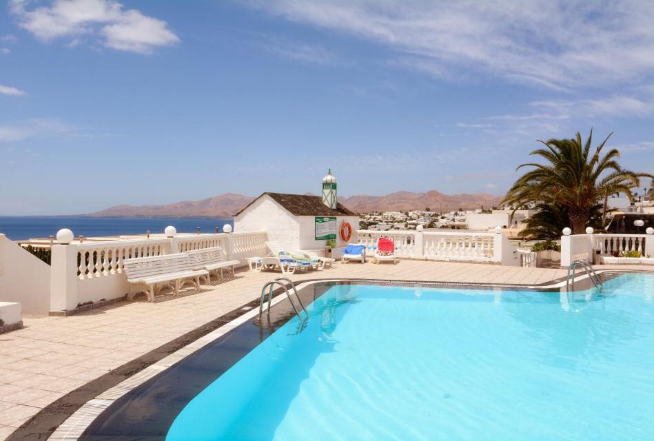 uma grande piscina com vista para o oceano em Budda house Puerto del carmen. em Tías