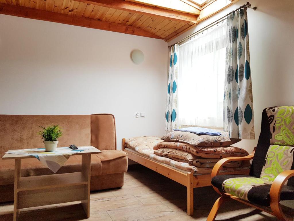 uma sala de estar com um sofá, uma mesa e uma janela em Ośrodek Kolonijno - Wypoczynkowy Ania em Leba