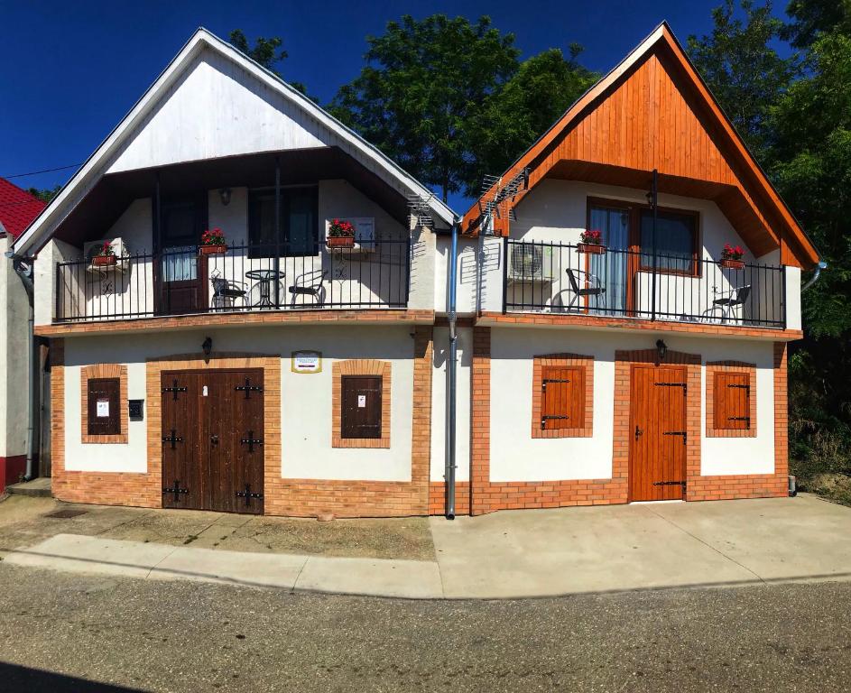 a house with two floors and a balcony at Berger Pince és vendégház in Császártöltés