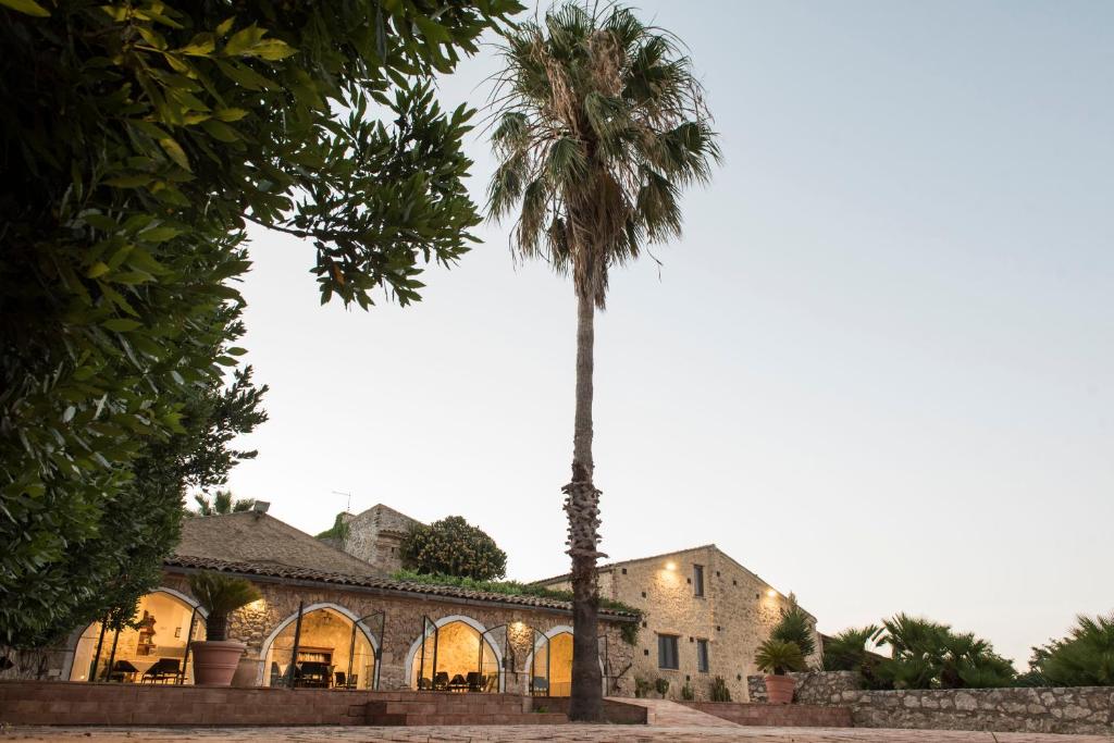 una palmera frente a un edificio en Agriturismo Baglio Làuria, en Campobello di Licata