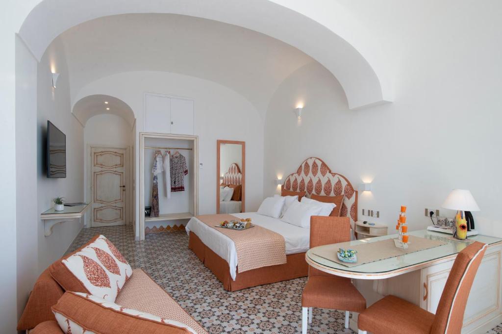 a hotel room with a bed and a table and chairs at CASA CAPRILE POSITANO in Positano