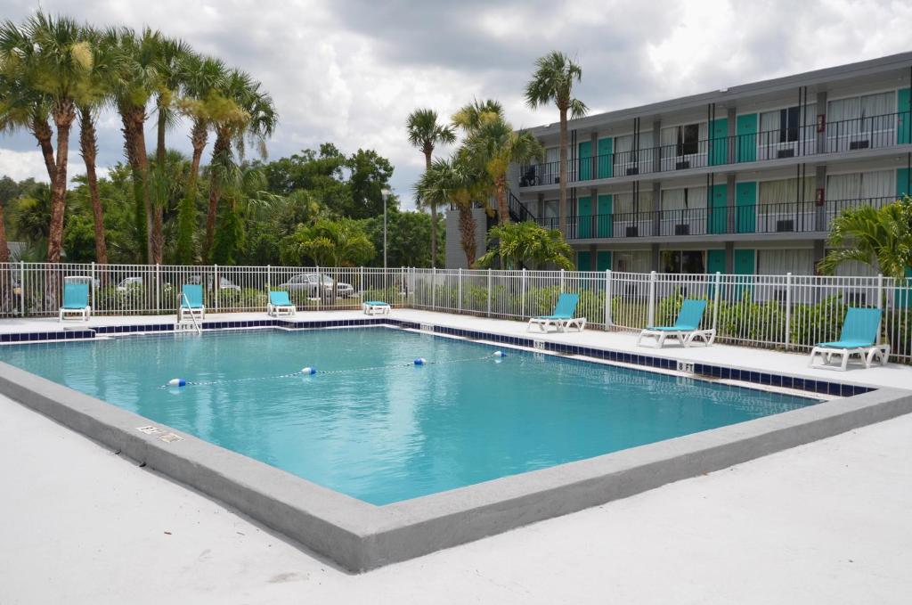 a large swimming pool with chairs and a building at Altamonte Springs Hotel and Suites in Orlando