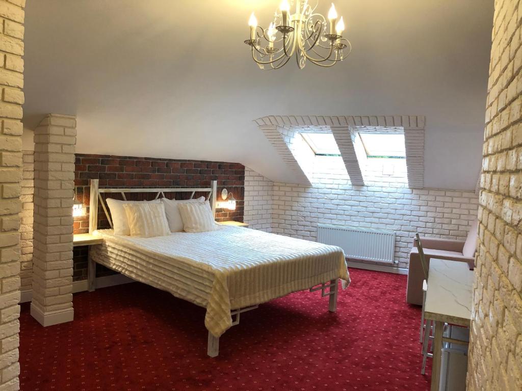 a bedroom with a bed and a chandelier at Hotel History in Velikiy Novgorod