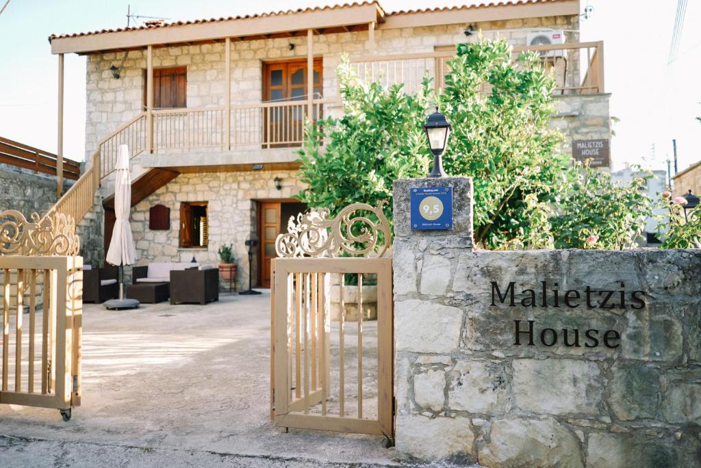 un cancello di fronte a un edificio con una casa di Malietzis House a Pano Arodes