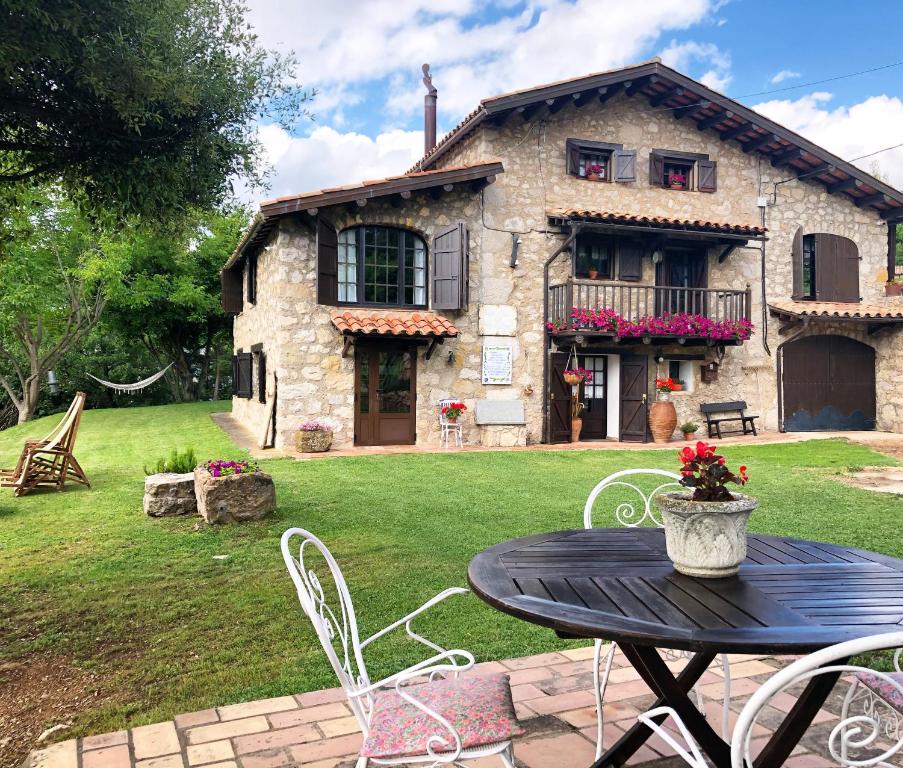 una casa de piedra con una mesa y sillas en un patio en Masia Cap del Roc, en Vallcebre