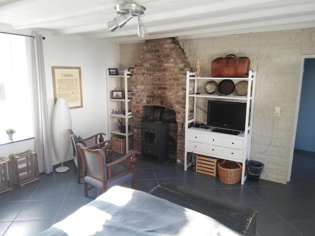 sala de estar con chimenea de ladrillo y TV en het Bakhuis en Hoensbroek