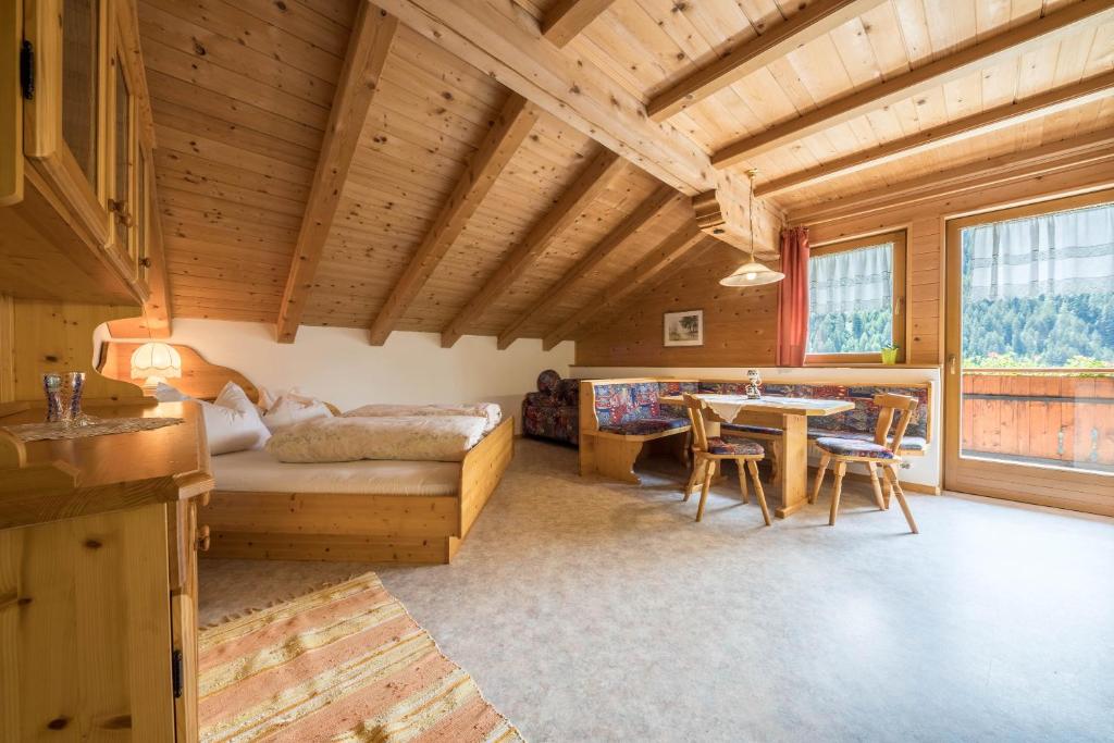 een slaapkamer met een bed en een tafel in een kamer bij Haus Hubertus - Fewo 5 in San Leonardo in Passiria