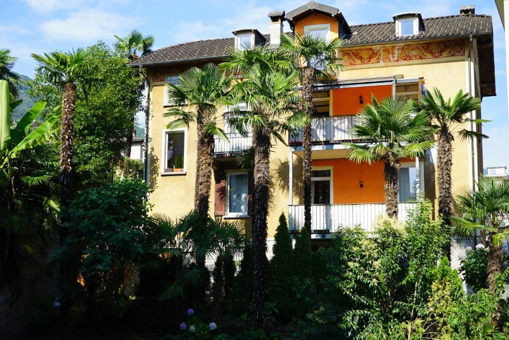 een oranje huis met palmbomen ervoor bij Baia del Re da joli e Amedeo Lago Maggiore in Minusio