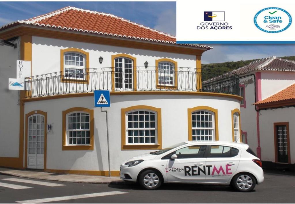 a car that is parked in front of a building at Hotel Branco I in Praia da Vitória