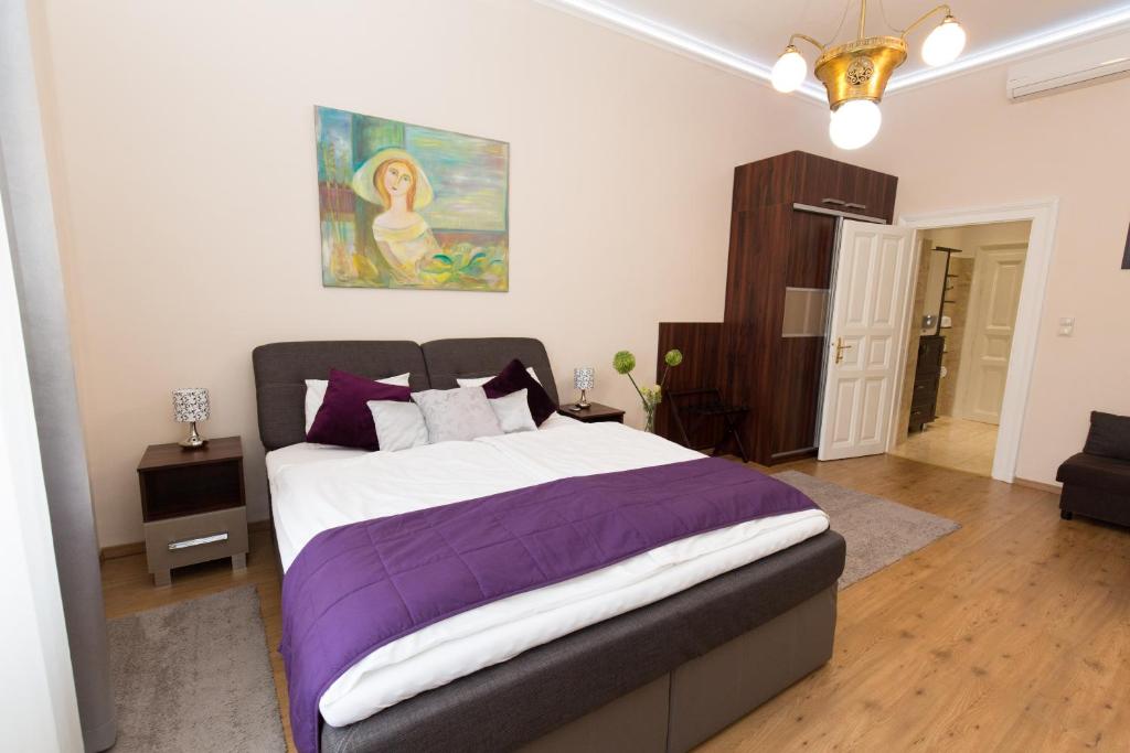 ein Schlafzimmer mit einem großen Bett mit einer lila Decke in der Unterkunft Elegant apartment with Buda Castle view in Budapest