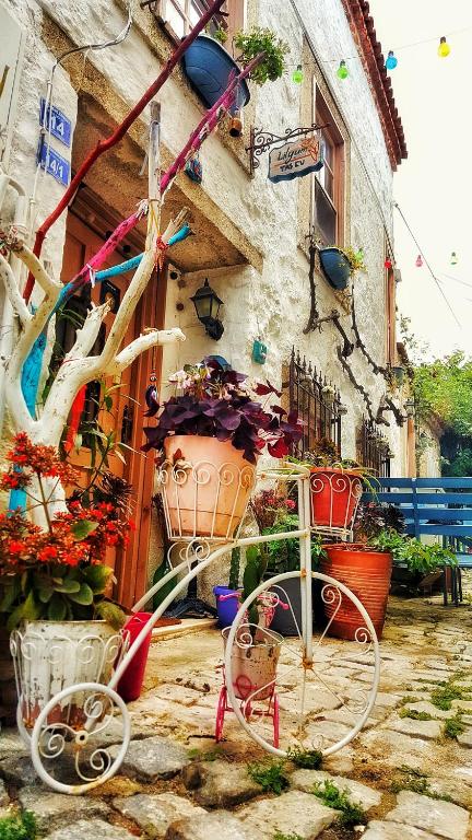 Ein Fahrrad, das vor einem Gebäude mit Blumen geparkt ist. in der Unterkunft Lilyum Alaçatı - Taş Ev in Alacati